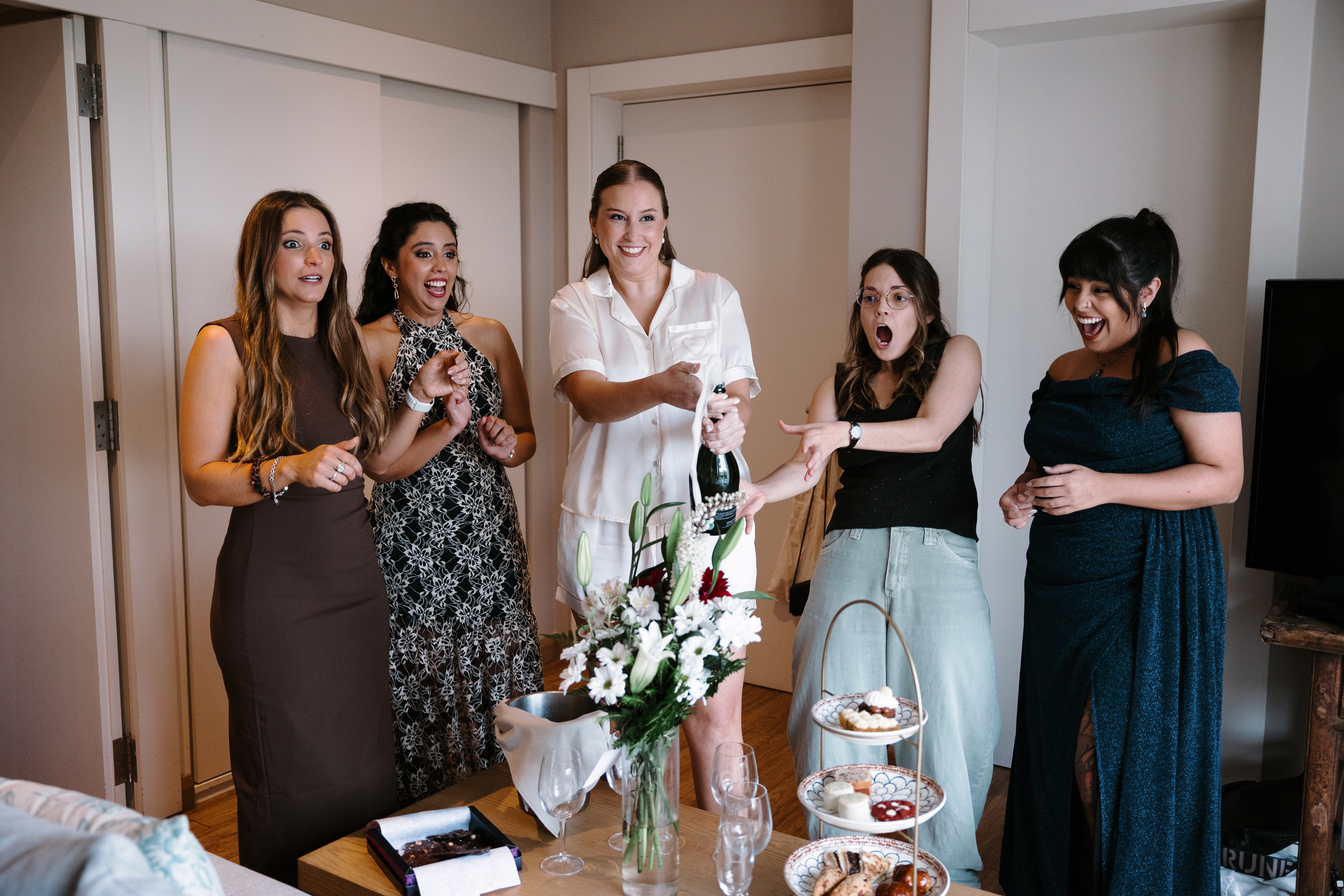 Novia y sus damas de honor celebrando con champaña