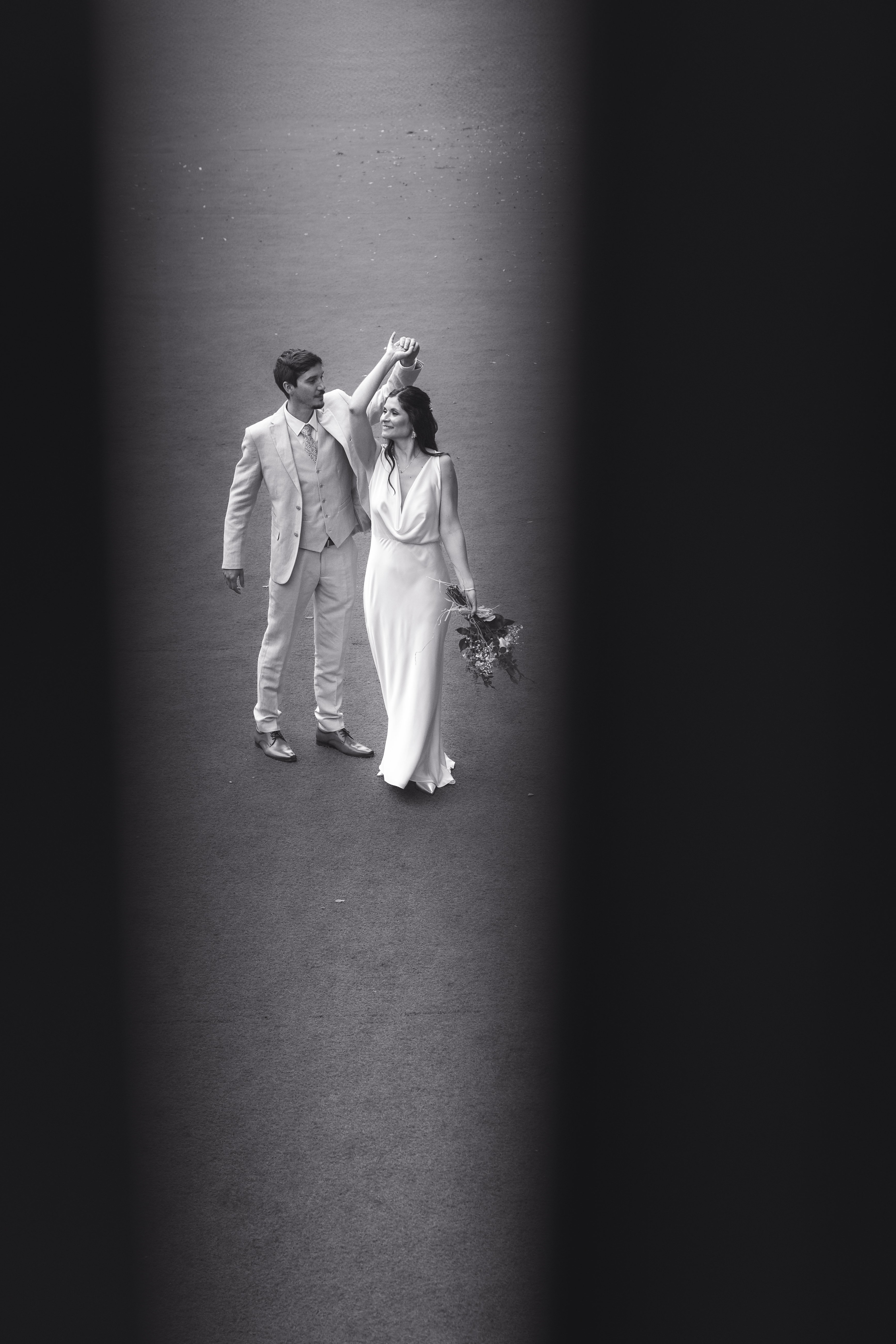 Novios bailando bajo un haz de luz en blanco y negro