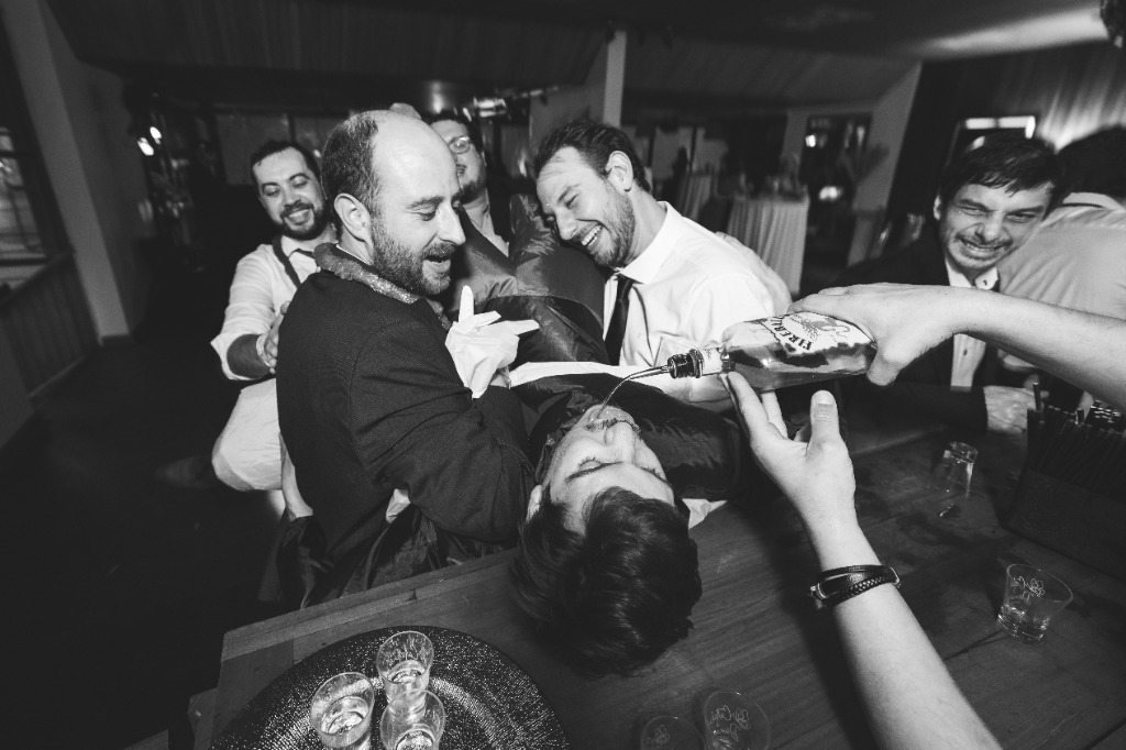 Novio y amigos celebrando en la barra del bar en blanco y negro